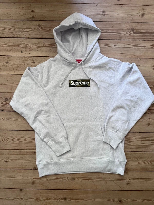 Before: flat-lay photo of a grey Supreme box logo hoodie
